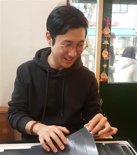 Photographer Seungwoo Kim reviewing his portraits of veterans